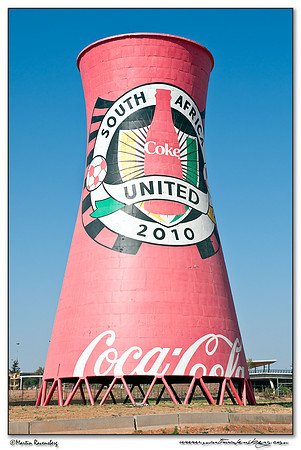 A giant cooling tower near the Soccer City Stadium with Coca Cola advertising in Soweto, Johannesburg.